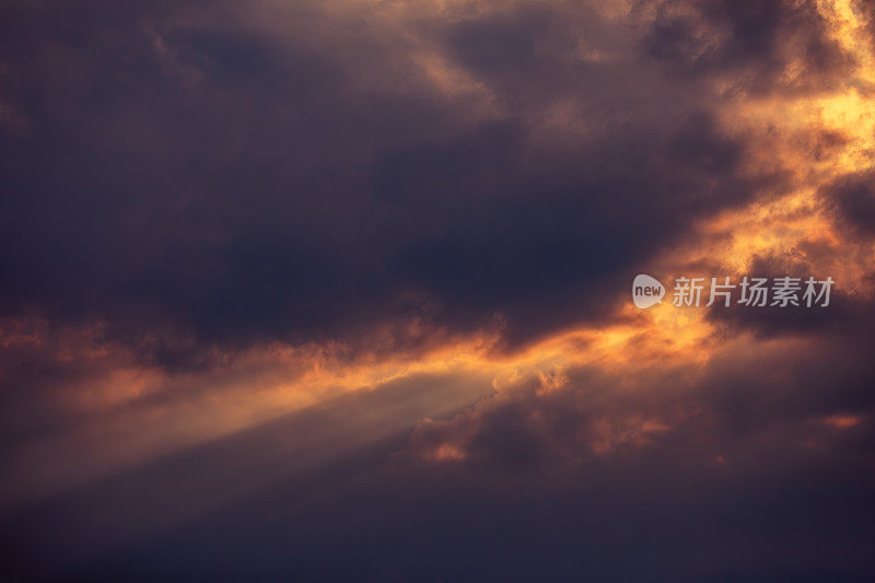 戏剧性的日落天空背景:阳光穿透黑色雷云