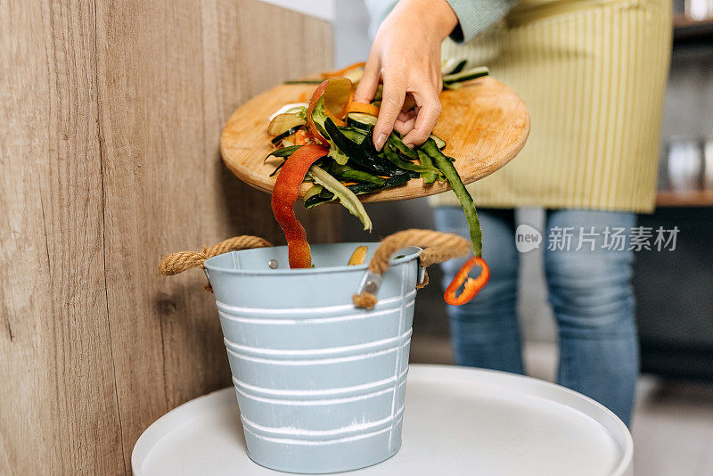 一个无法辨认的女人在家庭厨房里堆肥食物的特写镜头