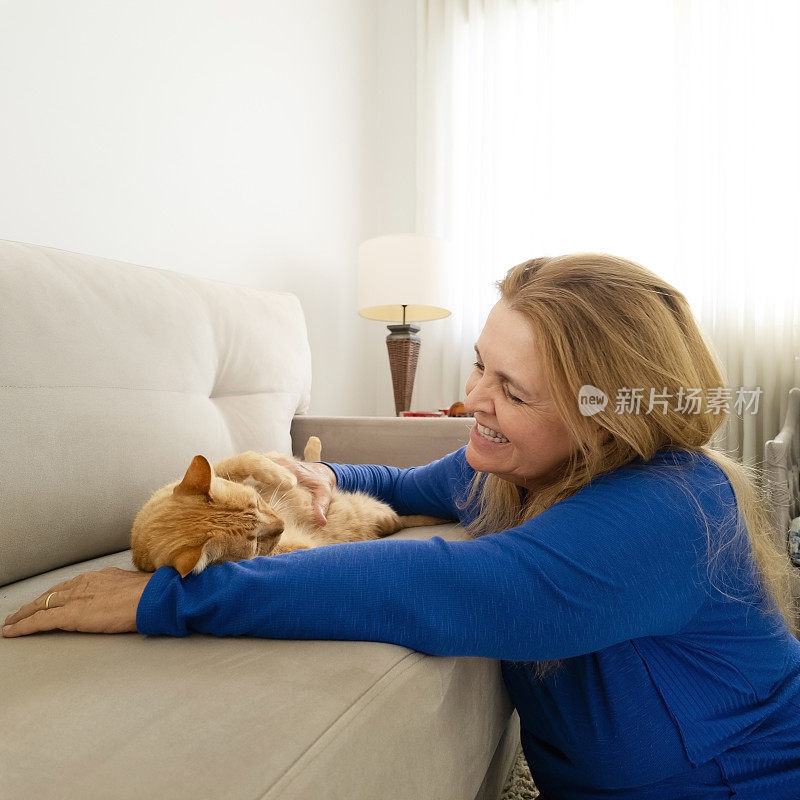 女人和他的姜黄色猫在家里。