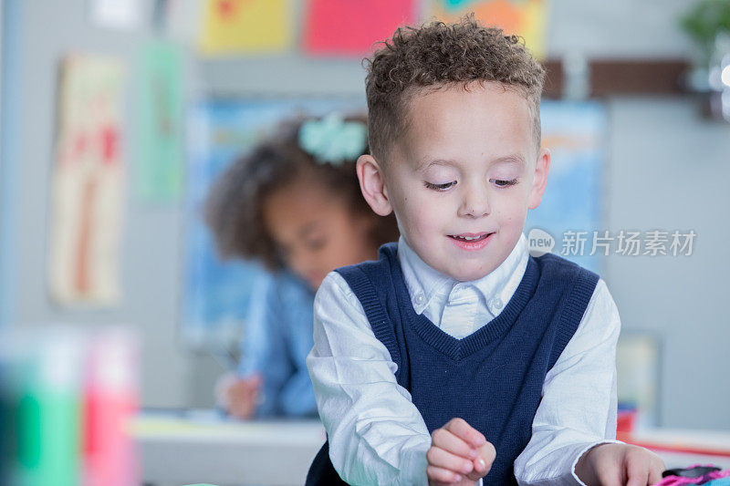 快乐的学龄前小男孩在学校的美术课上涂色