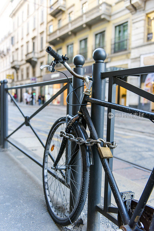 停在意大利米兰人行道上的一辆锁着的自行车