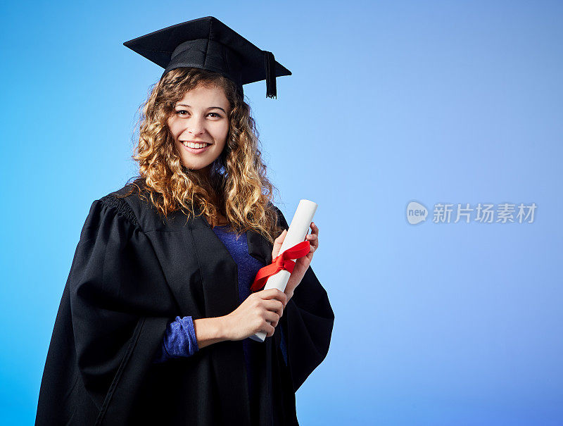 凯旋的年轻女毕业生自豪地持有文凭