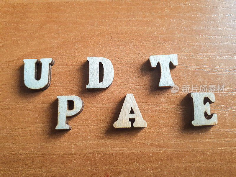 “update”这个词是由木制字母组成的。木头铭文