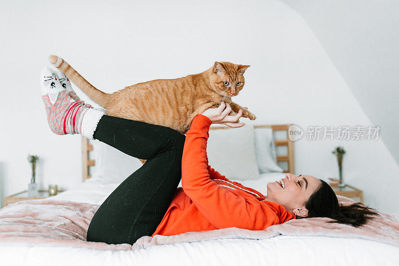 一个年轻女人和她的猫在床上