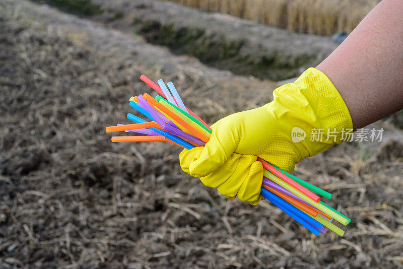 手持塑料吸管手套的手的特写——生态产业理念