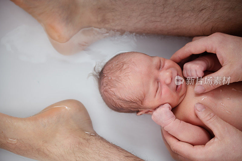 刚出生的男婴和他的父亲在浴室里
