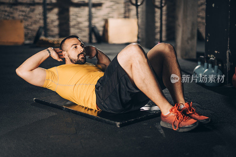 强壮的运动员在健身房做仰卧起坐运动