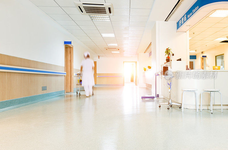 身着医疗制服的模糊人影穿过医院的走廊