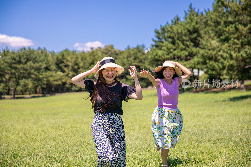 年轻女子在绿色的田野上奔跑