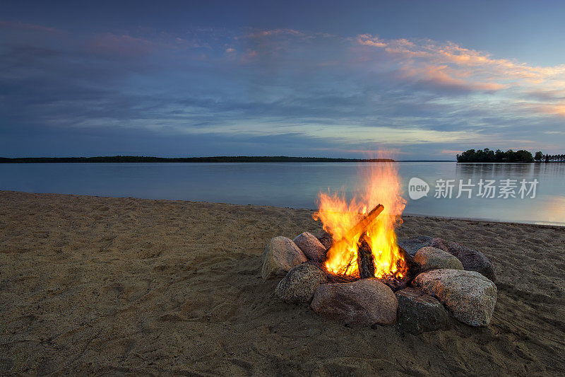 日落时分，在湖边营火。美国明尼苏达州