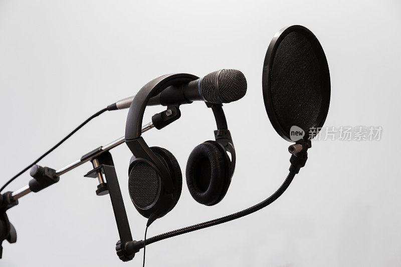 心脏型冷凝器麦克风，耳机和流行滤镜上的灰色背景。家庭录音室