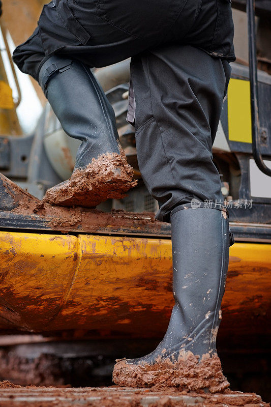 司机脚上满是泥浆的施工机械