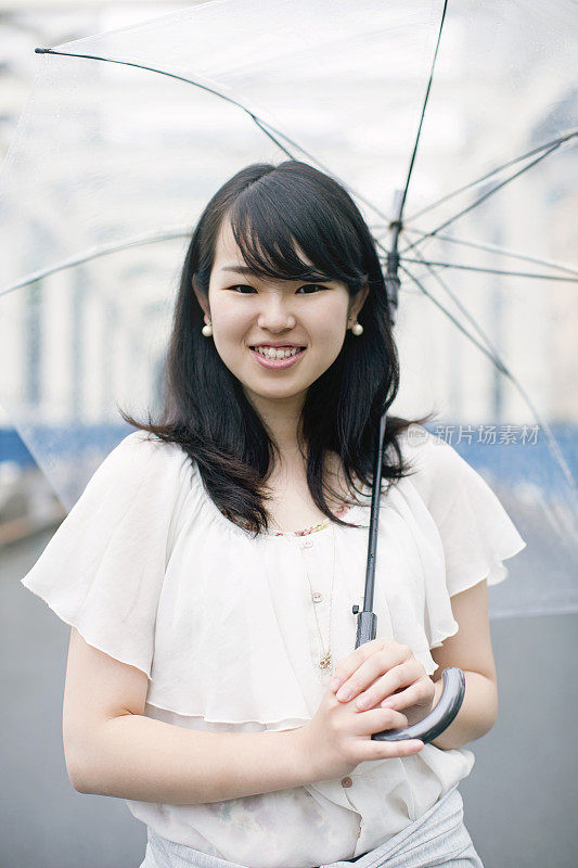 年轻的日本女人在东京的雨天户外