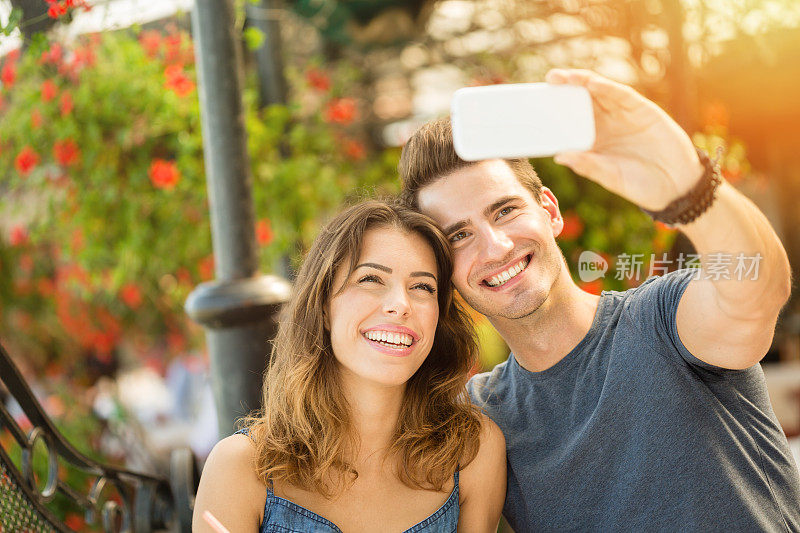 年轻情侣用智能手机拍照