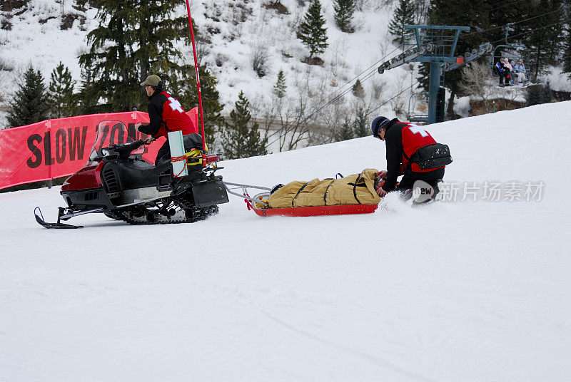 滑雪巡逻队运送受伤的滑雪者离开山腰