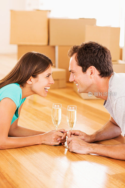 新婚夫妇在新房子里用香槟庆祝