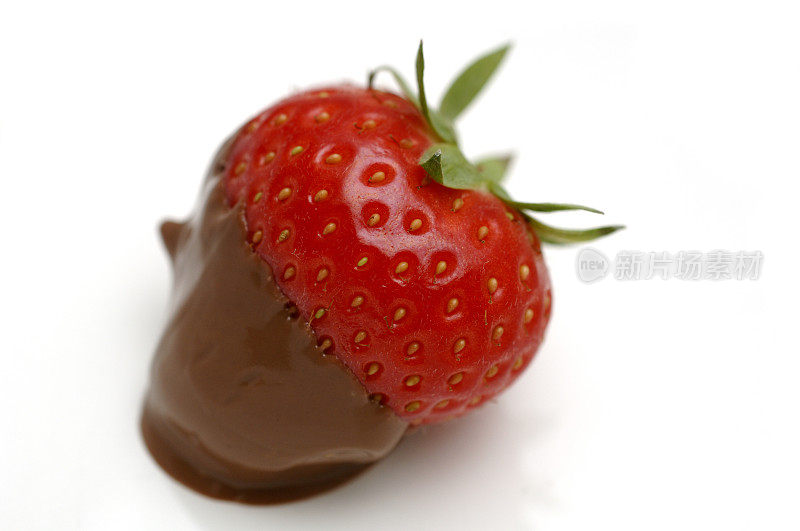 白盘子上放着蘸了草莓的巧克力