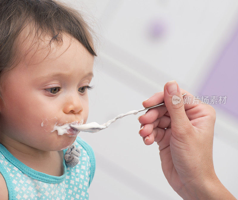 饥饿的婴儿在吃白酸奶。