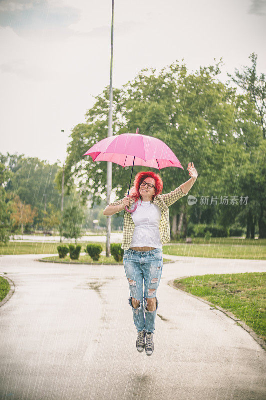 快乐的年轻女子与伞跳