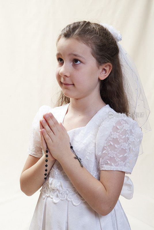 小女孩第一次领圣礼，手拿念珠