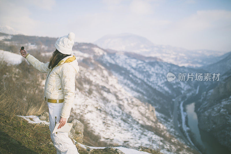 徒步旅行的妇女在山中阅读地图。