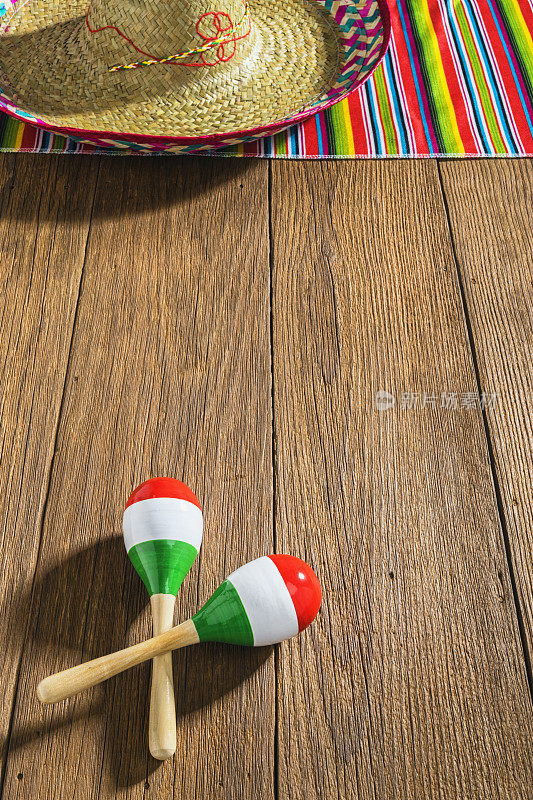 头顶上的墨西哥庆典用沙槌和宽边帽放在木板上