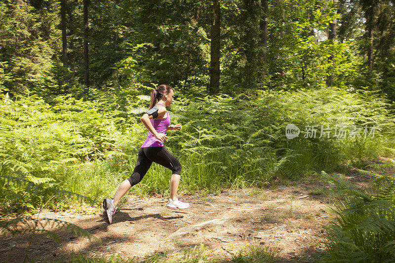 女人慢跑穿过森林小径