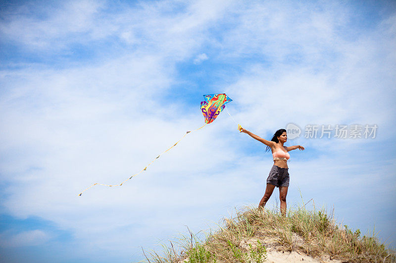 美丽的印度女人在海滩上放风筝