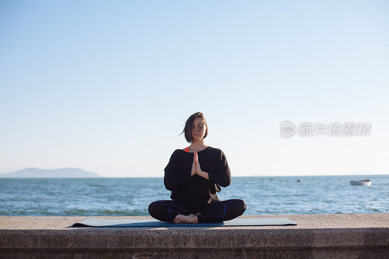 女人瑜伽放松在海边