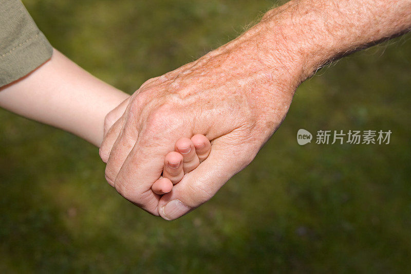 祖父和孙子手牵着手的特写