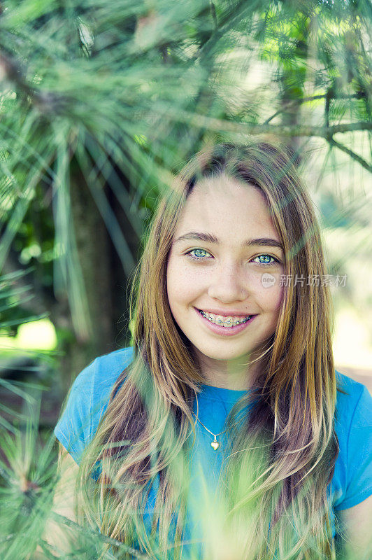 年轻女孩的肖像在松林微笑。