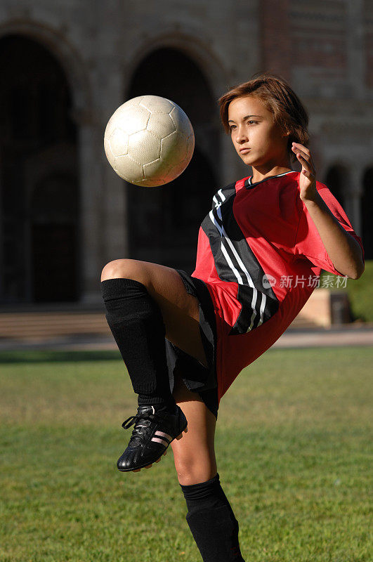 西班牙少女在膝盖上弹跳足球