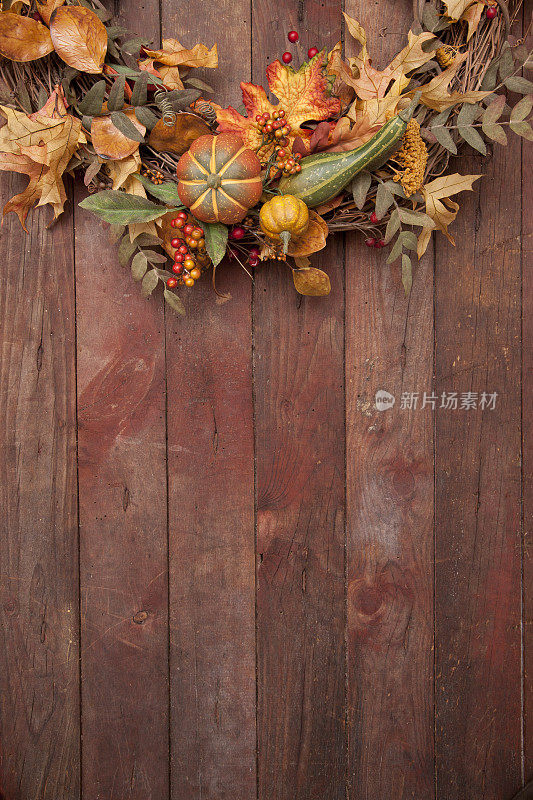 古老的农家谷仓门上的秋天花环