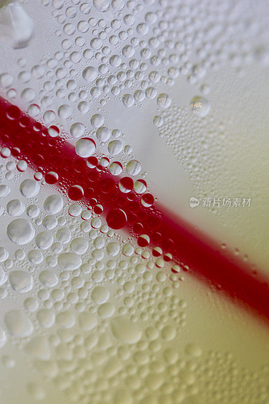 凝结的背景，一杯柠檬水和红色吸管的特写镜头。