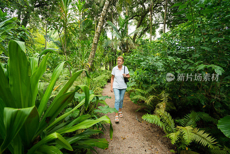 活跃的老妇人在热带花园散步