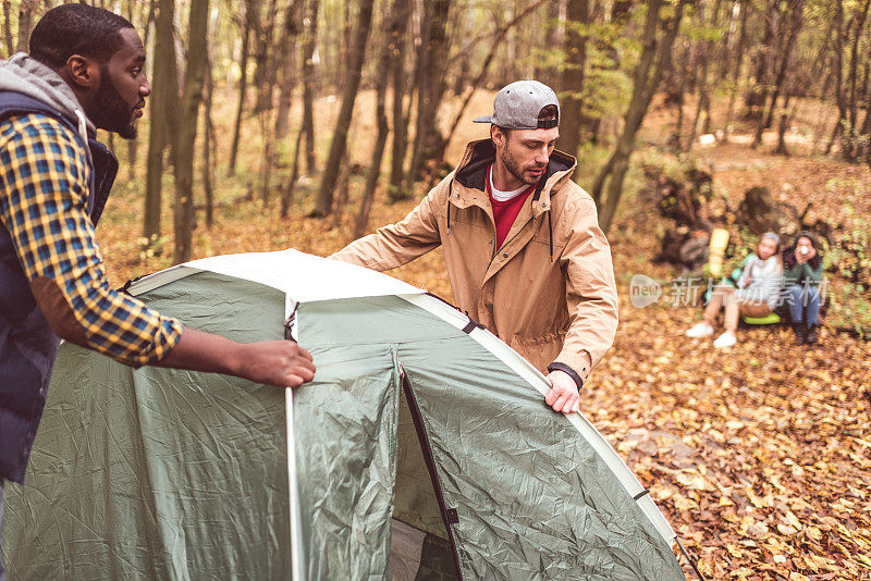 人们在秋天的森林里搭帐篷