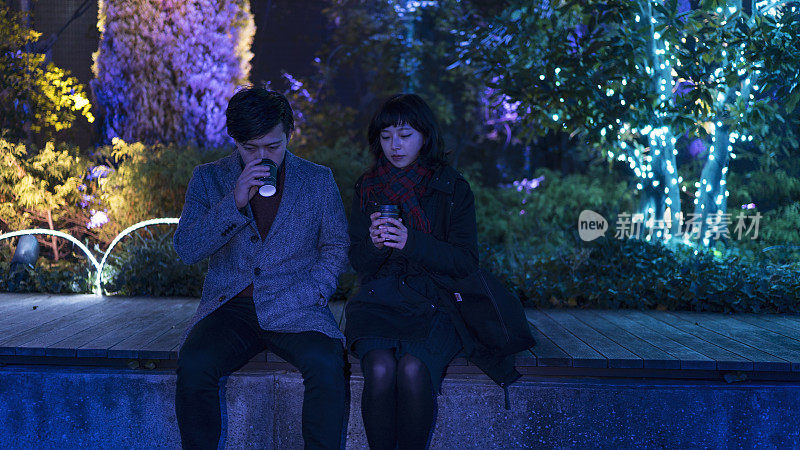 一对年轻夫妇在城市公园喝咖啡