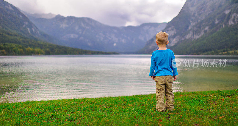 那男孩站在湖岸上向远方望去
