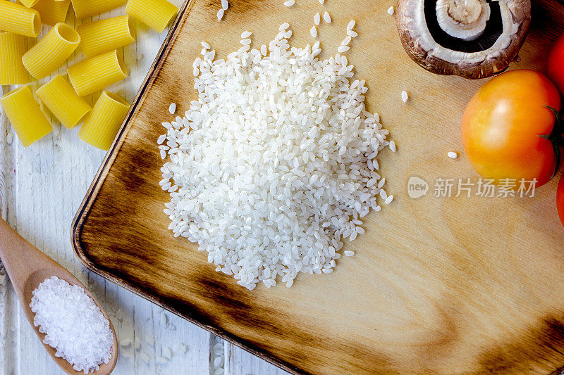 厨房板上的白米饭和周围的蔬菜俯视图。