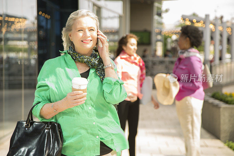 一位成年女性在市区使用手机。