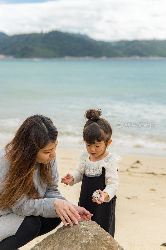 妈妈和小女孩在海滩上玩