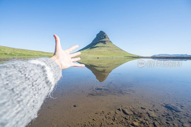 手伸向冰岛的Kirkjufell山