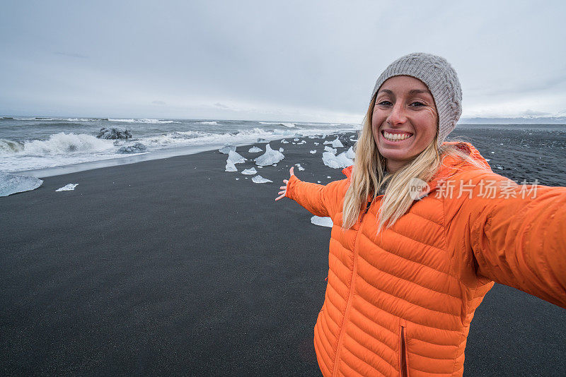 年轻女子在钻石海滩自拍黑沙，冰山上的海滩-冰岛