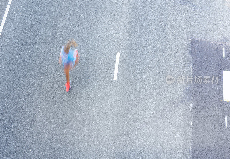 女运动员在马路上跑步