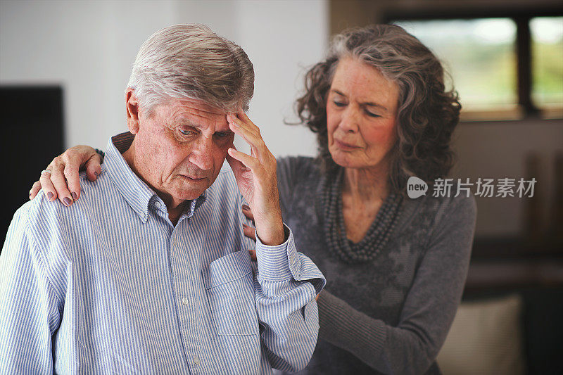 一位年长的女性肩膀上扶着一位收到坏消息的男士