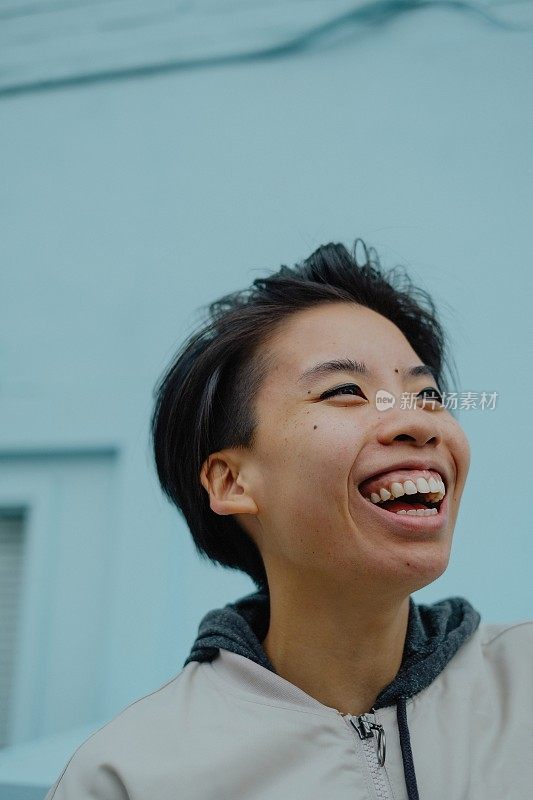 一个中国女人在蓝墙前笑