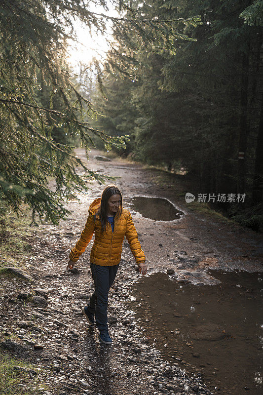 回归自然。独自在树林里行走的旅行者。一个快乐的年轻女游客漫步在大自然中。阳光明媚的日子里在森林里的户外享受。