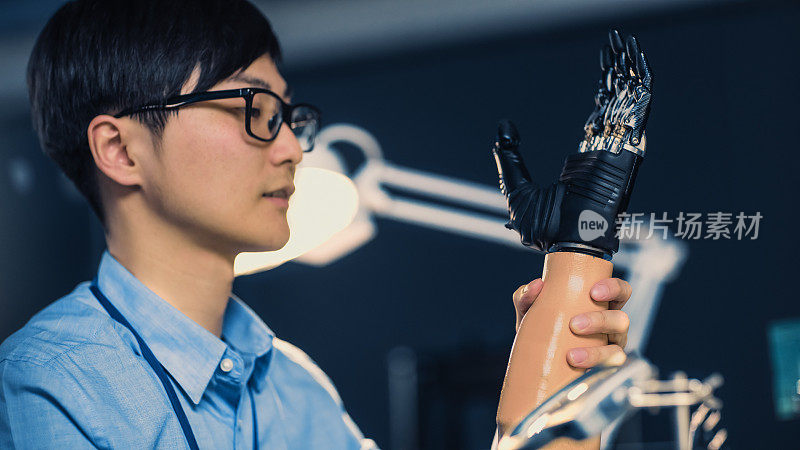 一个未来的假体机器人手臂被专业的日本开发工程师测试在一个高科技研究实验室与现代计算机设备的近距离。
