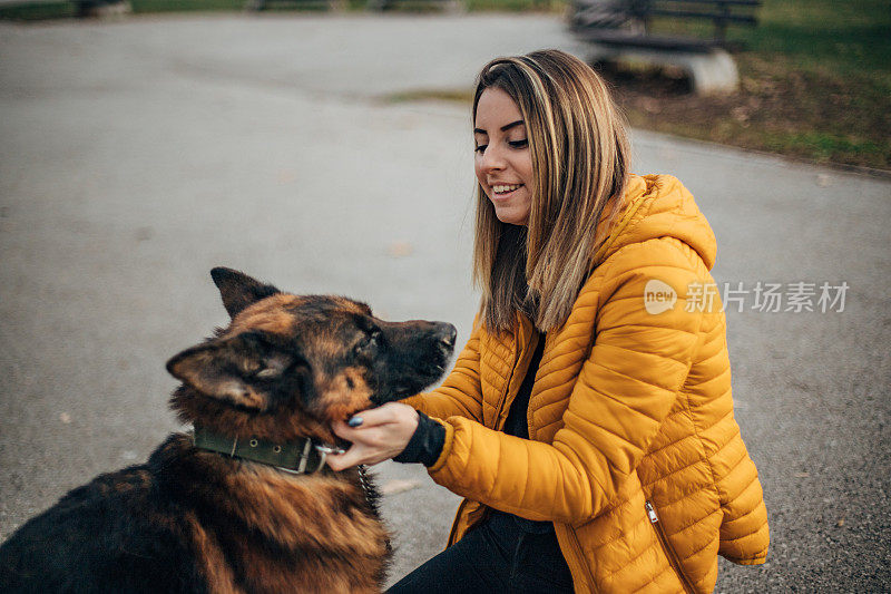 年轻女子和德国牧羊犬在公园里玩