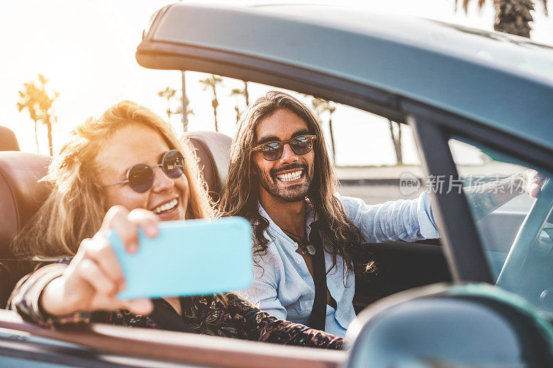 快乐的人们在敞篷车制作视频为社交网络-年轻夫妇享受户外cabriolet假日-旅游，青年生活方式和旅游的概念-关注男人的脸